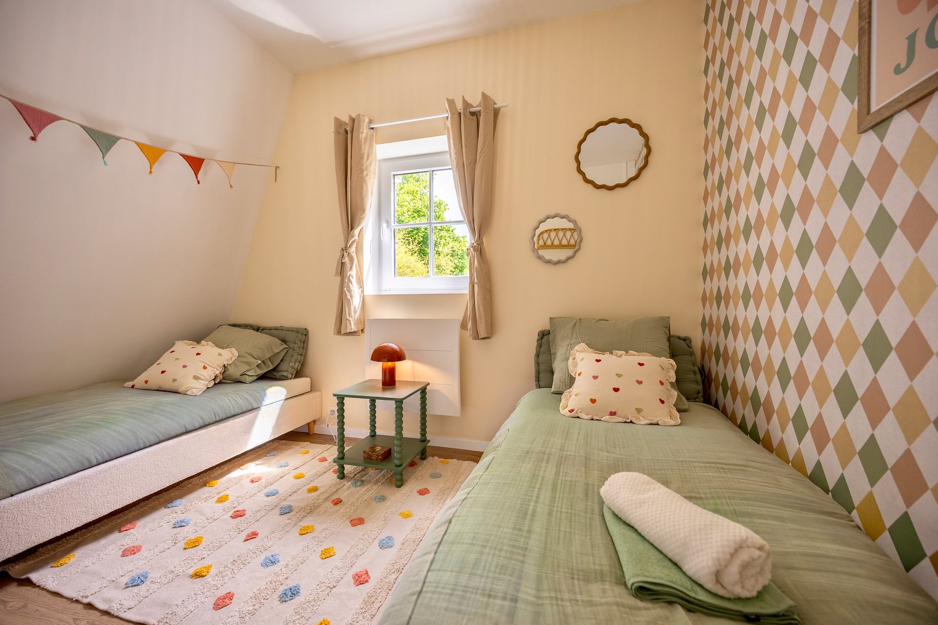 Chambre avec deux lits simples, papier losanges et guirlande
